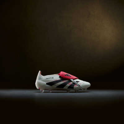 Side profile of the Adidas Predator boot showcasing red medial and lateral lines inspired by the 1998 Predator Accelerator